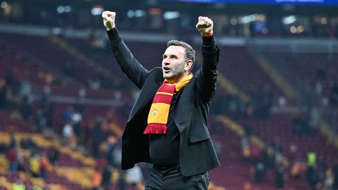 Okan Buruk, Galatasaray atkısıyla tribünler önünde iki yumruğunu havaya kaldırıyor.