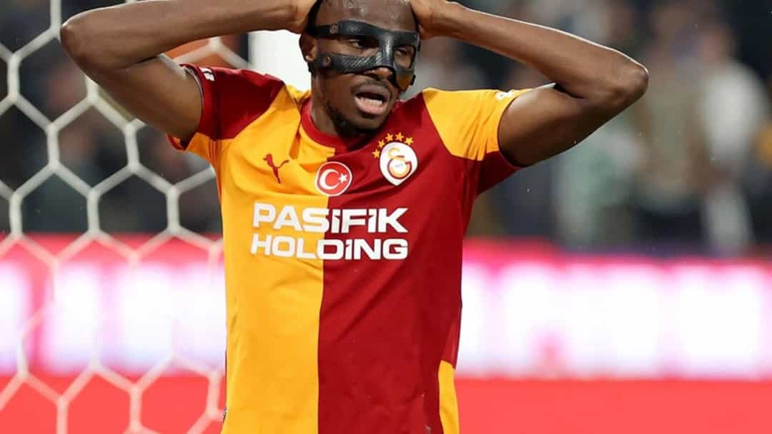Victor Osimhen, yüz maskesiyle maç sırasında ellerini başına koymuş halde.