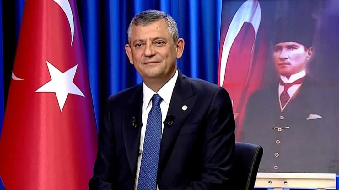 Özgür Özel, Türk bayrağı ve Atatürk portresinin önünde oturuyor.