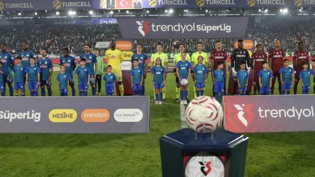 Rizespor ve Trabzonspor futbolcuları maç öncesinde sahada yan yana diziliyor.
