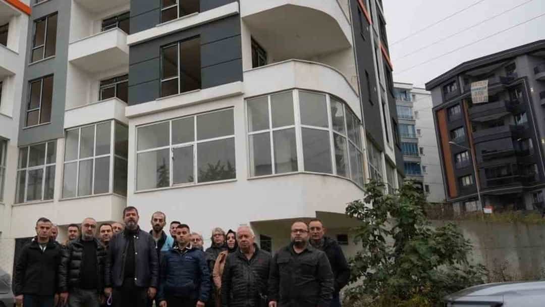 Bir apartman binasının önünde dairelerine kavuşamadıklarını belirten bir grup kişi duruyor.