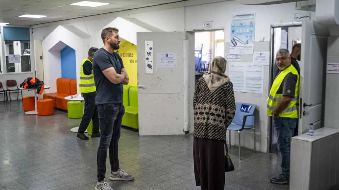 Bir seçim merkezinde görevliler ve oy kullanmaya gelen bir kadın.