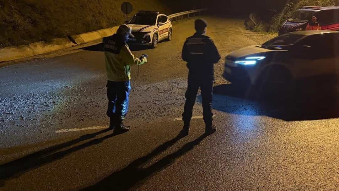 Gece saatlerinde yolda yapılan denetimde görevliler araçları kontrol ediyor.