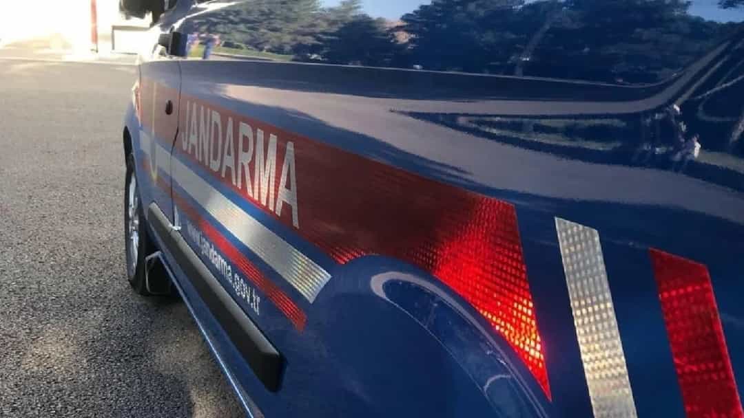 Yol kenarında park etmiş jandarma aracının yan görünümü.
