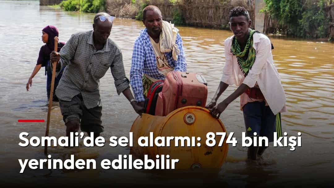 Somali’de sel sularının içinden eşyalarını taşıyan insanlar.