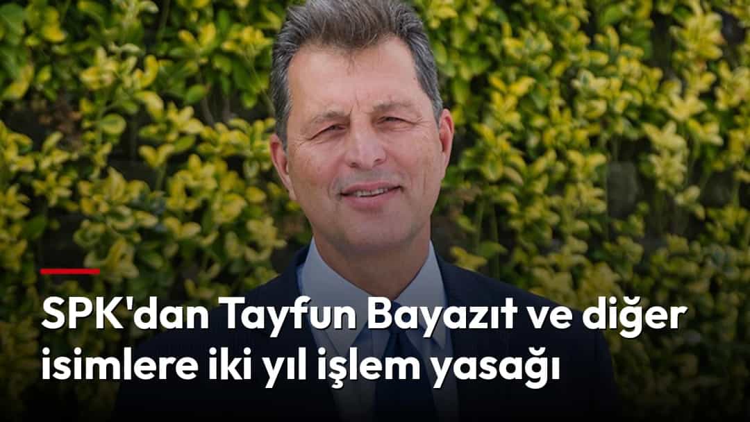 Tayfun Bayazıt, koyu renk takım elbise ve mavi kravatla poz veriyor.