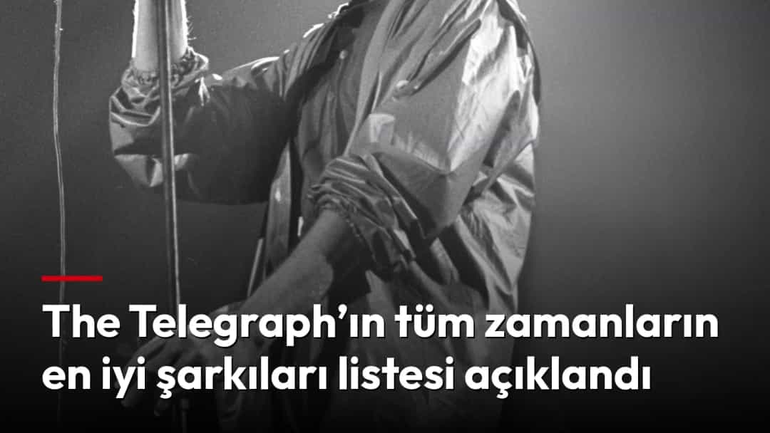 David Bowie sahnede mikrofonla şarkı söylüyor.