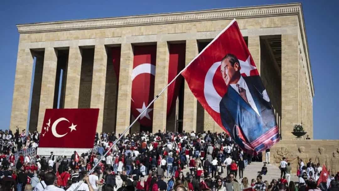 Anıtkabir önünde toplanan kalabalık, Türk bayrakları ve üzerinde Atatürk portresi bulunan büyük bir bayrak taşıyor.