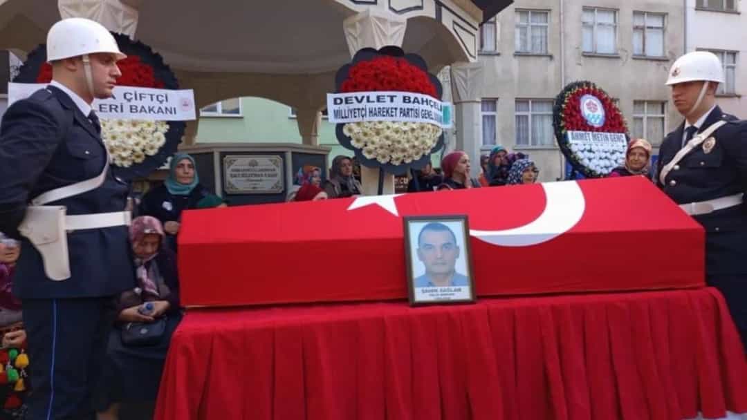 Tören alanında Türk bayrağına sarılı tabutun başında nöbet tutan polisler