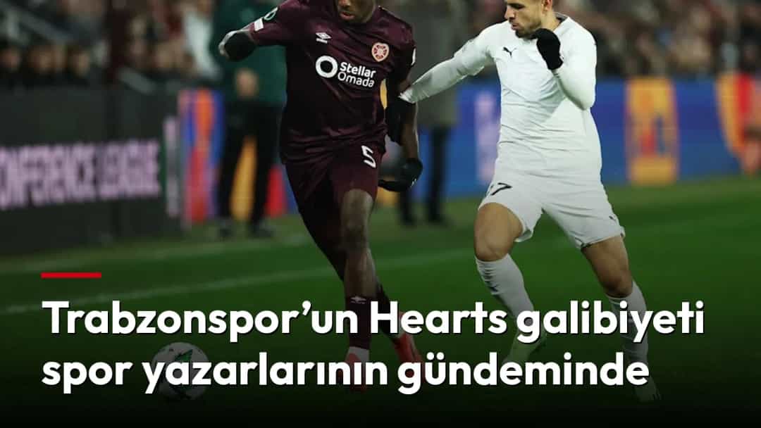 Heartsli oyuncu ile Trabzonspor forması giyen futbolcu maç sırasında topa doğru mücadele ediyor.