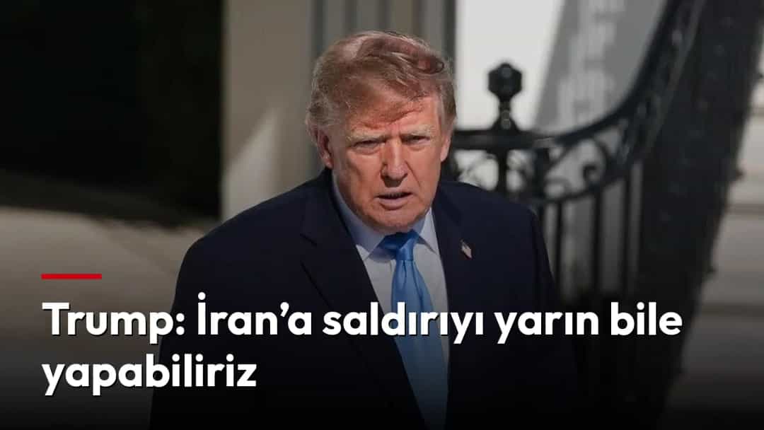 Donald Trump, koyu renk takım elbisesiyle bir binanın girişinde yürüyor.