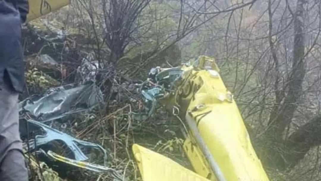 Ağaçlık arazide düşen helikopterin sarı renkli enkazı