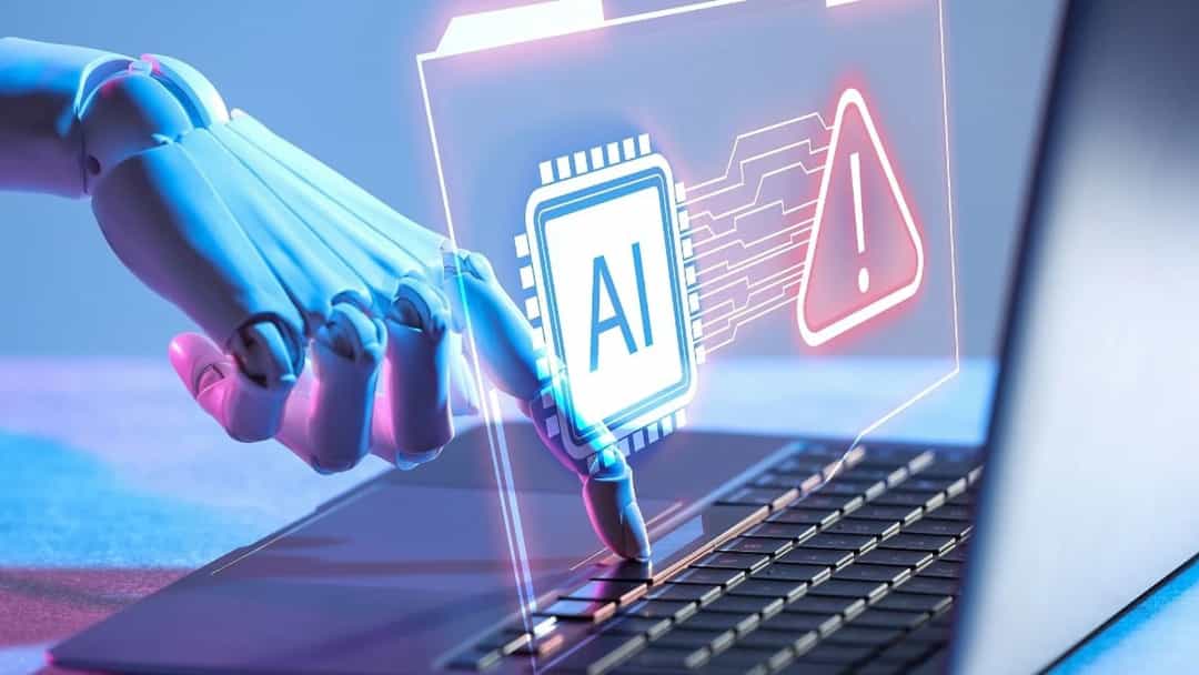 Yapay zekâyı simgeleyen robotik bir el, dizüstü bilgisayarın klavyesine dokunuyor; ekranda yapay zekâ ve uyarı simgeleri görülüyor.