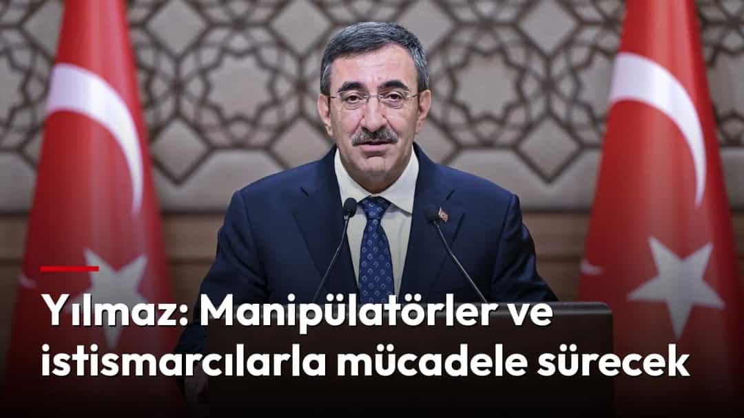 Cevdet Yılmaz, Türk bayrakları önünde kürsüde konuşma yapıyor.