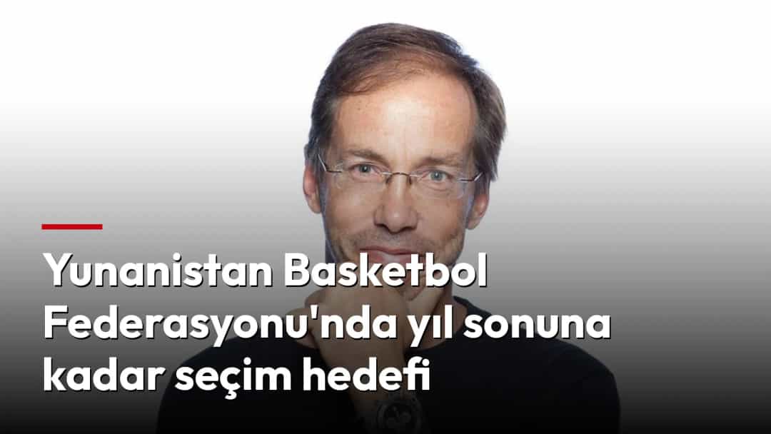 Beyaz fonda, gözlüklü Yorgos Mavrotas siyah tişörtüyle elini çenesine dayamış halde.