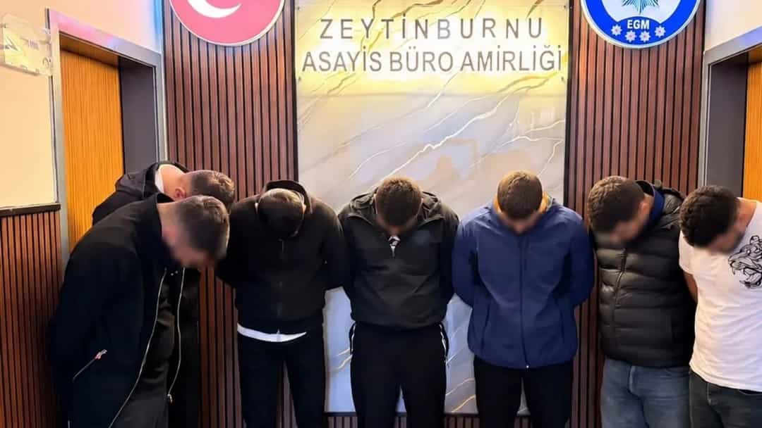 Zeytinburnu Asayiş Büro Amirliği önünde başları öne eğik halde yan yana duran altı kişi.