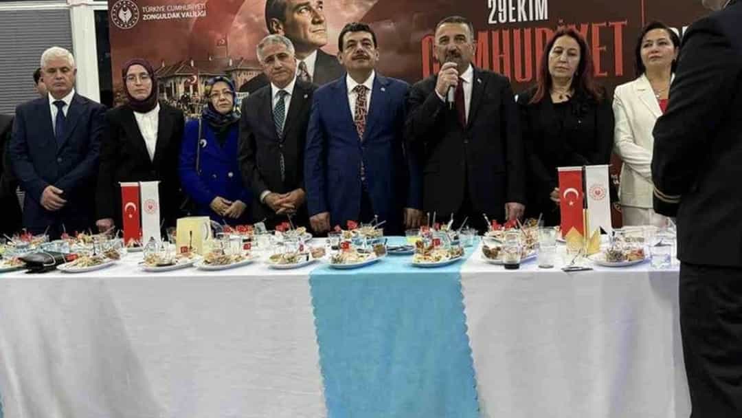 Zonguldak’taki 29 Ekim resepsiyonunda davetliler masanın arkasında toplandı; ortadaki konuklardan biri mikrofonla konuşuyor.